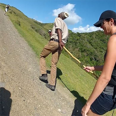 A guide helps a hiker up a hill